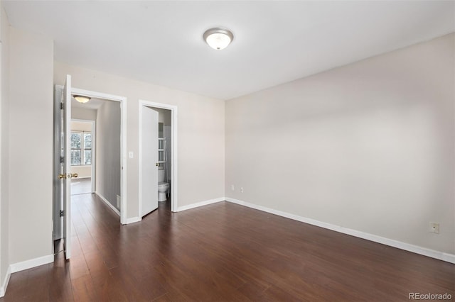 empty room with dark hardwood / wood-style flooring