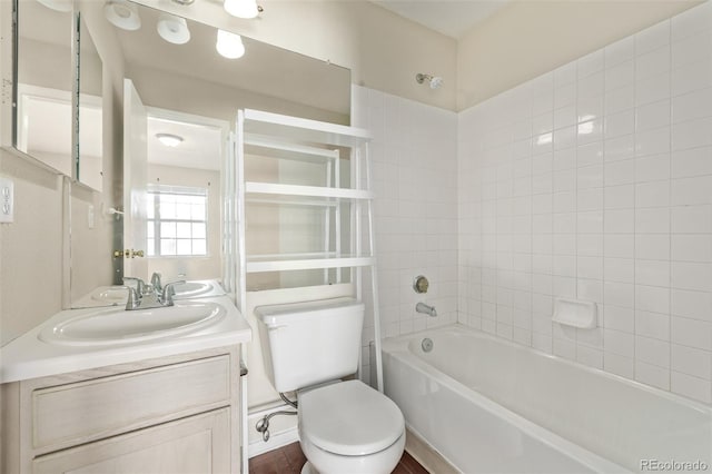 full bathroom featuring vanity, tiled shower / bath, and toilet