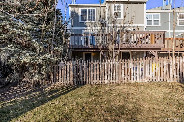 back of property featuring a deck and a yard