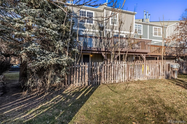 back of house with a deck and a lawn