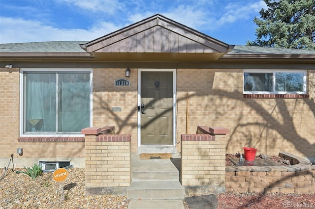 11360 Irma Dr, Northglenn, CO 80233 - view of exterior entry with brick siding and a shingled roof