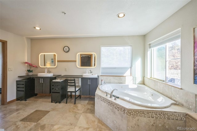 bathroom with vanity and tiled tub