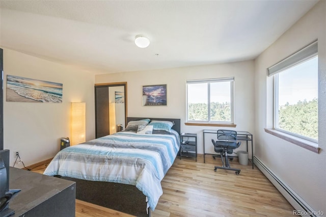 bedroom featuring light wood-type flooring and baseboard heating