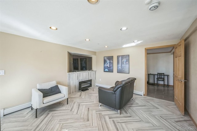 living room with baseboard heating, a fireplace, and light parquet flooring