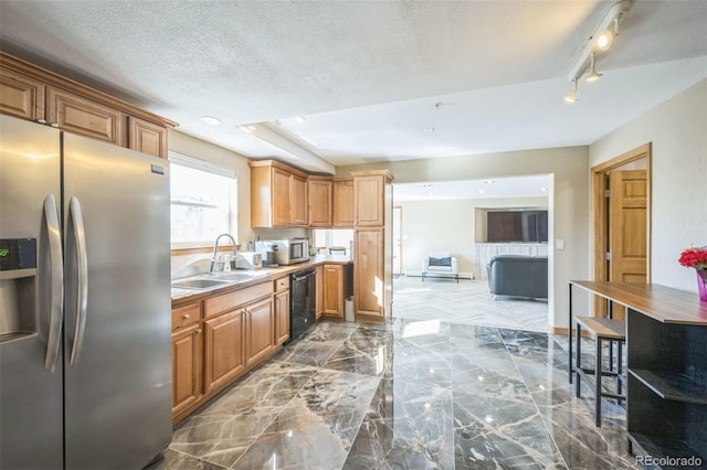 kitchen with a textured ceiling, sink, and appliances with stainless steel finishes