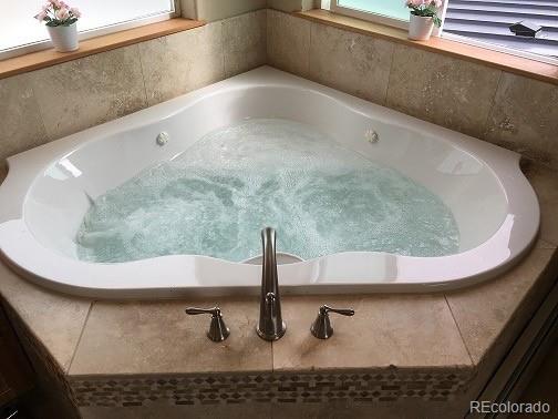 details with a jacuzzi and a bath