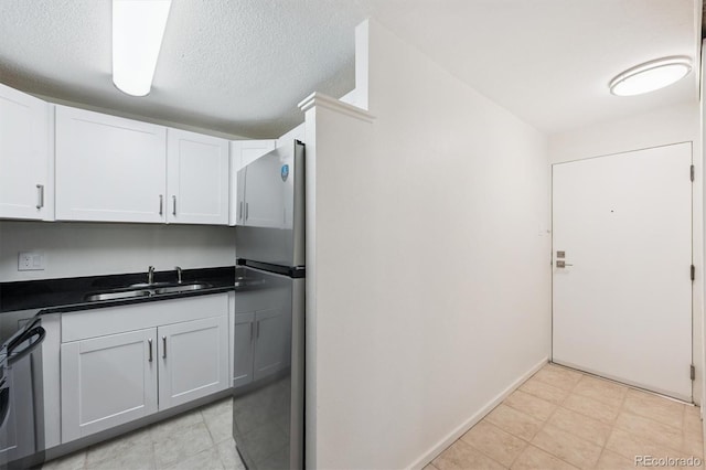 1029 E 8th Ave Unit 603, Denver, CO 80218 - kitchen featuring appliances with stainless steel finishes, dark countertops, white cabinetry, and a textured ceiling