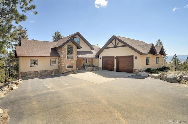 30220 Columbia Pt, Buena Vista, CO 81211 - english style home featuring stone siding, stucco siding, an attached garage, driveway, and roof with shingles