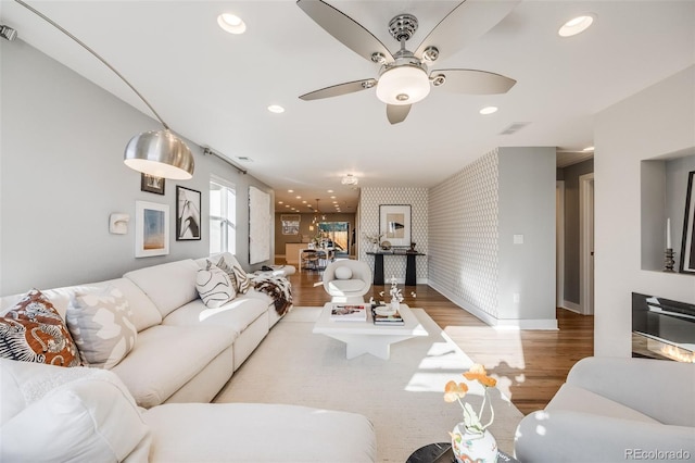 living room with wallpapered walls, visible vents, baseboards, wood finished floors, and recessed lighting