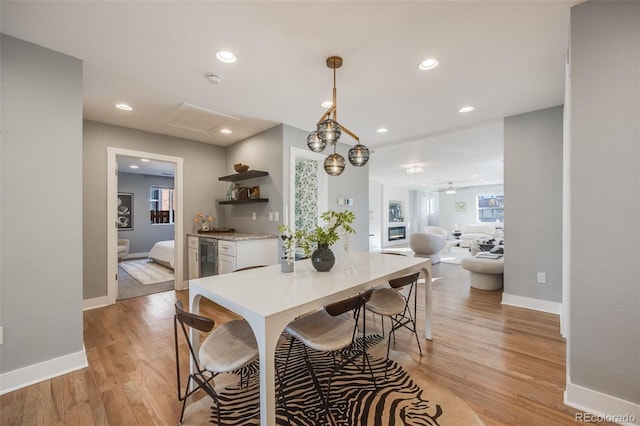 dining room featuring baseboards, light wood finished floors, attic access, and recessed lighting