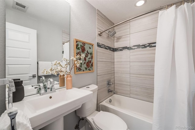 bathroom featuring visible vents, shower / bath combo, a sink, and toilet