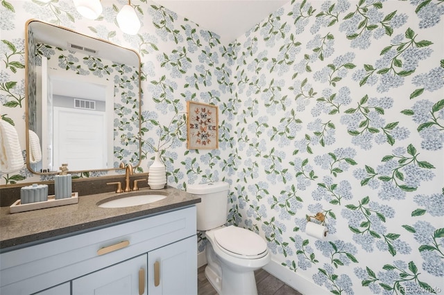 bathroom featuring toilet, wallpapered walls, visible vents, and vanity