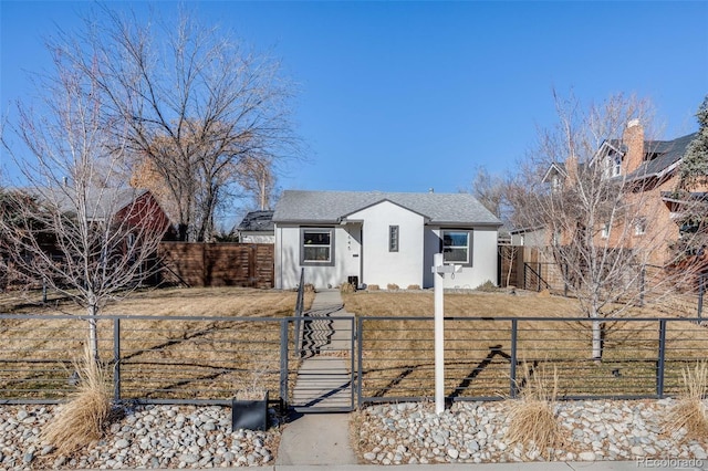 view of front of house with a fenced front yard, a gate, and stucco siding