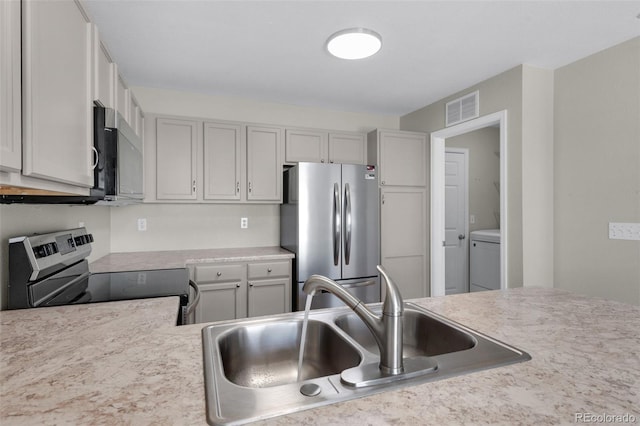 3456 Osprey Ridge Dr, Colorado Springs, CO 80916 - kitchen with appliances with stainless steel finishes, a sink, light countertops, and washer / dryer