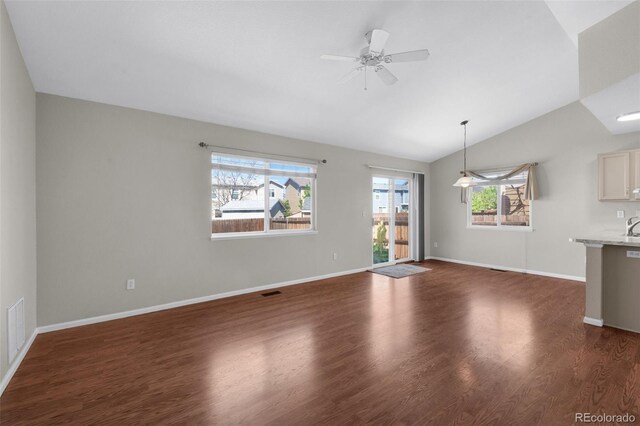 3456 Osprey Ridge Dr, Colorado Springs, CO 80916 - unfurnished living room with vaulted ceiling, dark wood-style flooring, a ceiling fan, and baseboards