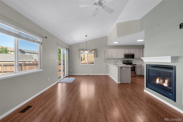 3456 Osprey Ridge Dr, Colorado Springs, CO 80916 - kitchen with appliances with stainless steel finishes, a sink, a peninsula, light countertops, and a glass covered fireplace