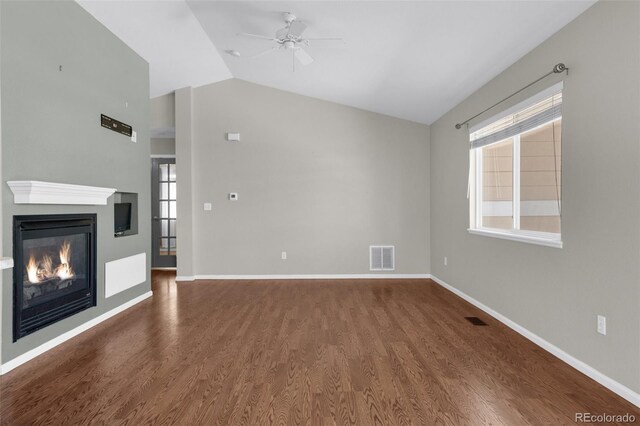 3456 Osprey Ridge Dr, Colorado Springs, CO 80916 - unfurnished living room featuring vaulted ceiling, a ceiling fan, wood finished floors, a glass covered fireplace, and baseboards
