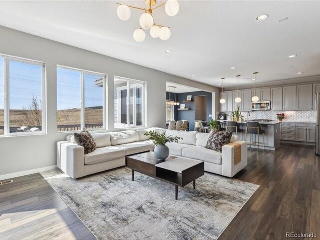 11426 Box Turtle Ct, Parker, CO 80134 - living area featuring a chandelier, dark wood-type flooring, recessed lighting, and baseboards
