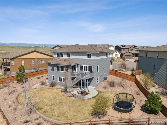 11426 Box Turtle Ct, Parker, CO 80134 - rear view of house featuring an outdoor fire pit, a deck, stairway, a fenced backyard, and a residential view