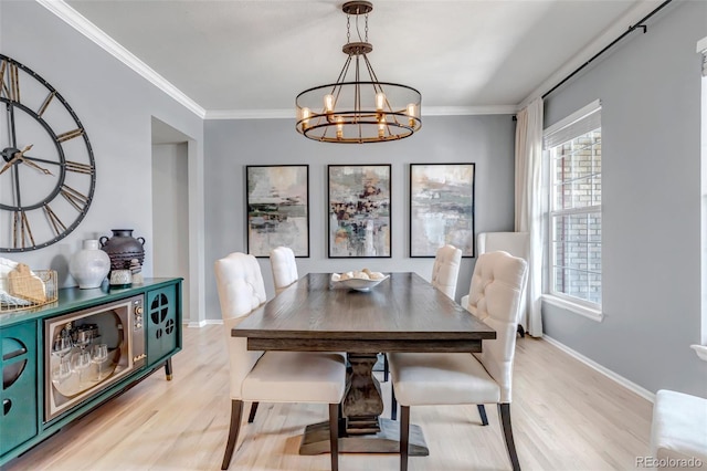 dining room featuring light wood-style floors, baseboards, ornamental molding, and an inviting chandelier