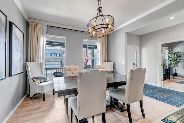 dining room with a wealth of natural light, light wood finished floors, and a notable chandelier