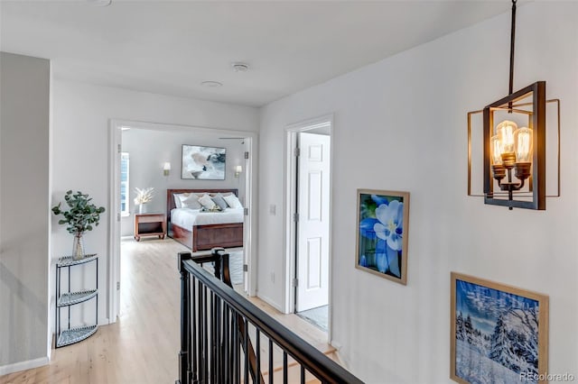hall featuring light wood-style flooring and baseboards