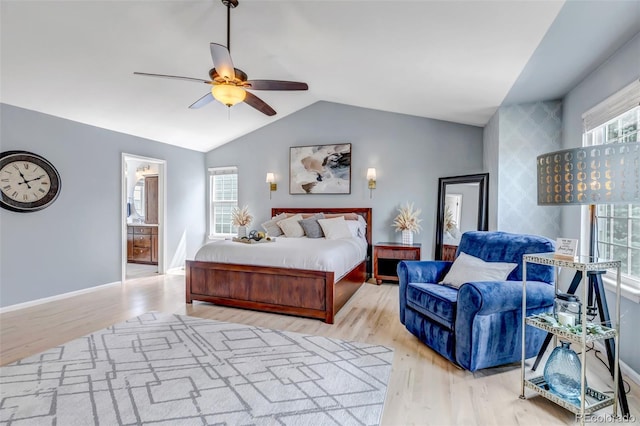 bedroom with ensuite bath, lofted ceiling, a ceiling fan, and wood finished floors