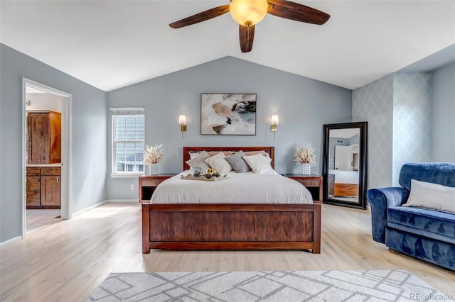 bedroom featuring light wood-style flooring, vaulted ceiling, baseboards, an accent wall, and wallpapered walls