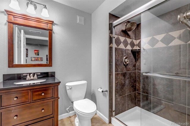 full bathroom featuring visible vents, toilet, vanity, baseboards, and a stall shower