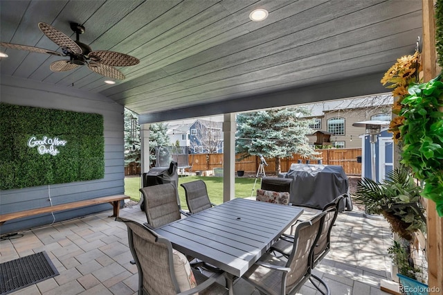 view of patio / terrace with grilling area, a fenced backyard, a ceiling fan, and outdoor dining area
