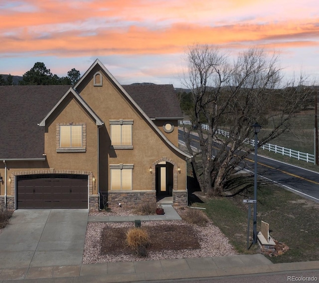 1890 Bel Lago Vw, Monument, CO 80132 - view of front of home featuring stone siding, stucco siding, concrete driveway, and a garage