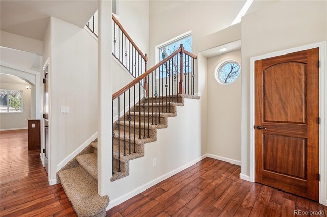 1890 Bel Lago Vw, Monument, CO 80132 - entryway featuring arched walkways, plenty of natural light, dark wood-type flooring, baseboards, and a high ceiling