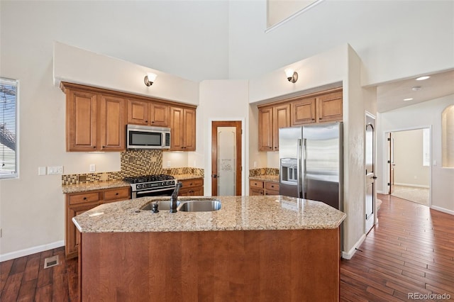 1890 Bel Lago Vw, Monument, CO 80132 - kitchen featuring appliances with stainless steel finishes, a sink, brown cabinets, baseboards, and dark wood-style floors