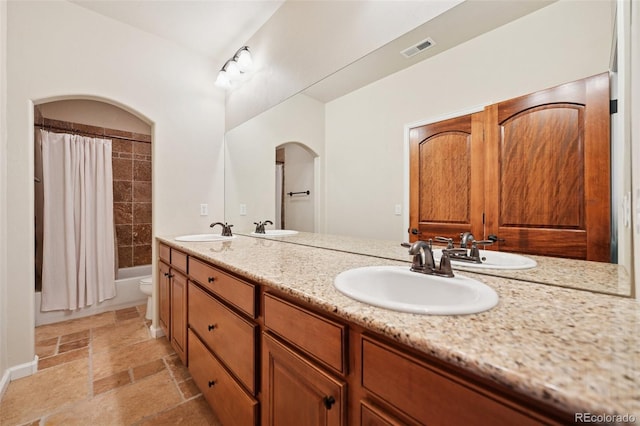 1890 Bel Lago Vw, Monument, CO 80132 - full bath with double vanity, toilet, stone tile floors, and shower / tub combo
