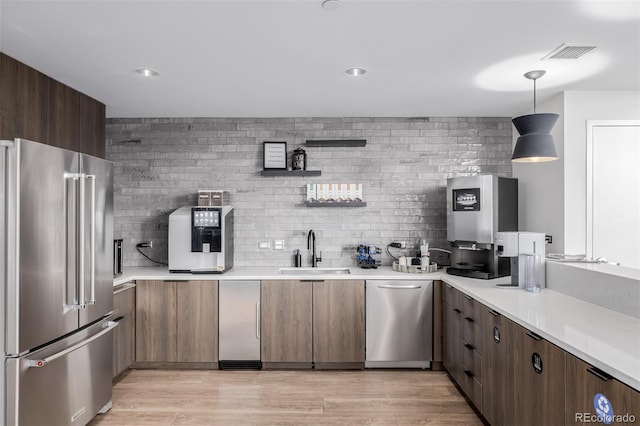 1700 Bassett St Unit 513, Denver, CO 80202 - kitchen featuring appliances with stainless steel finishes, a sink, light countertops, decorative backsplash, and recessed lighting