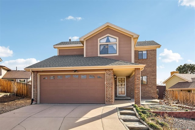 traditional home featuring brick siding, a shingled roof, driveway, and fence