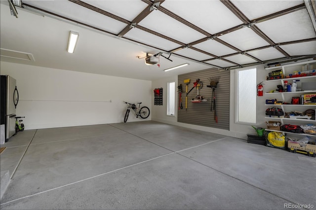 garage with freestanding refrigerator and a garage door opener