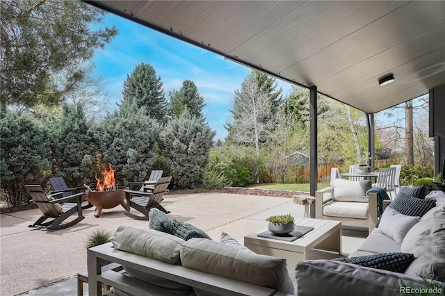 view of patio / terrace with an outdoor living space with a fire pit and fence
