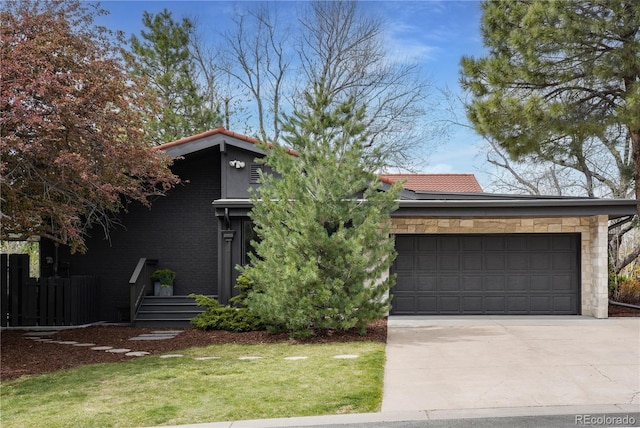 mid-century home with concrete driveway, a garage, and a front yard