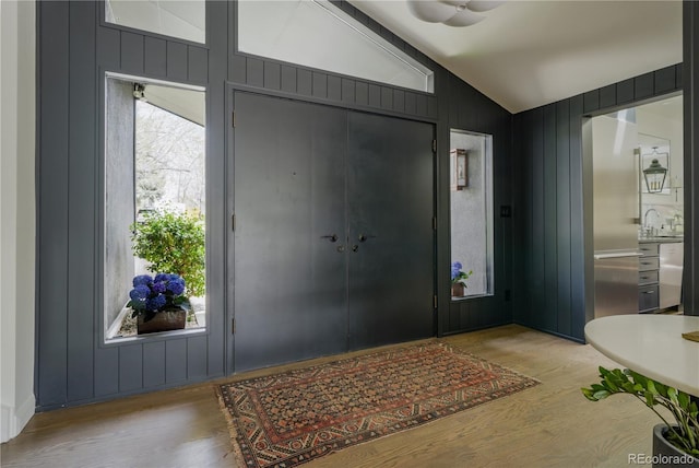 foyer with wood finished floors and lofted ceiling