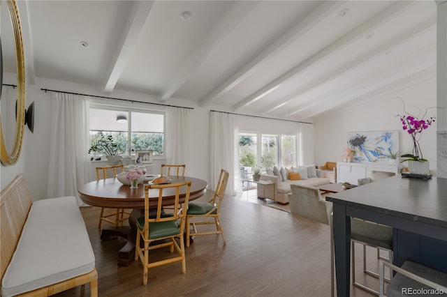 dining room with lofted ceiling with beams and wood finished floors