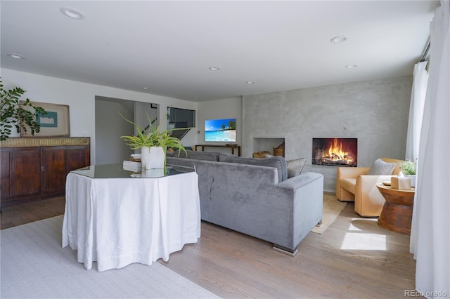 living room with light wood finished floors, a fireplace, and recessed lighting