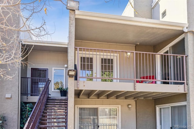 entrance to property with a balcony and stucco siding