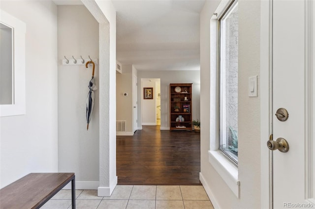 foyer entrance featuring visible vents, baseboards, and light tile patterned flooring