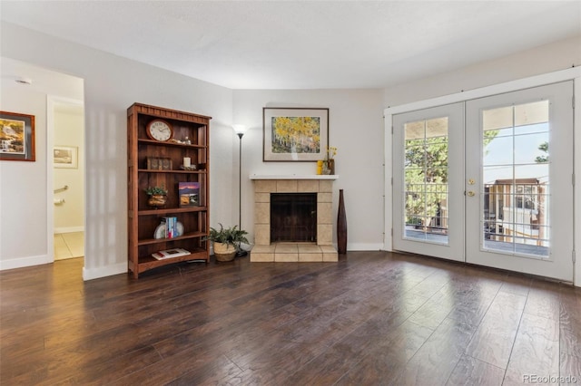 living room featuring french doors, wood finished floors, baseboards, and a tile fireplace
