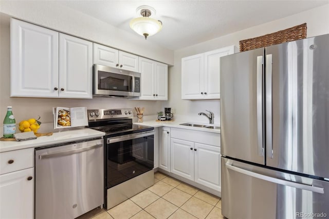 kitchen with light countertops, white cabinetry, a sink, and appliances with stainless steel finishes