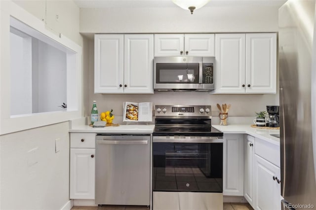 kitchen featuring white cabinets, light tile patterned floors, light countertops, and appliances with stainless steel finishes
