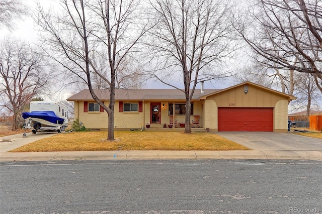 single story home with a garage, brick siding, fence, concrete driveway, and a front lawn