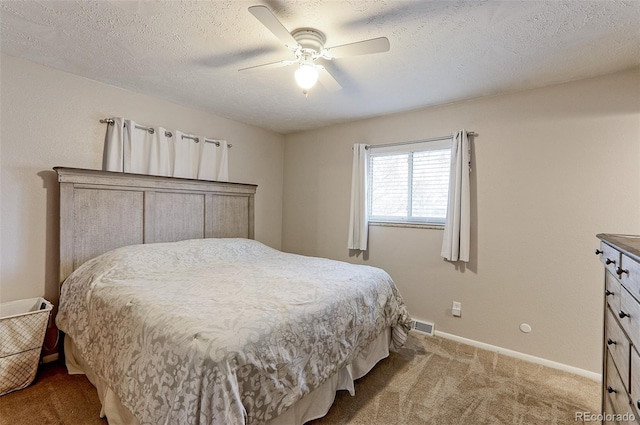 carpeted bedroom with a textured ceiling, a ceiling fan, and baseboards