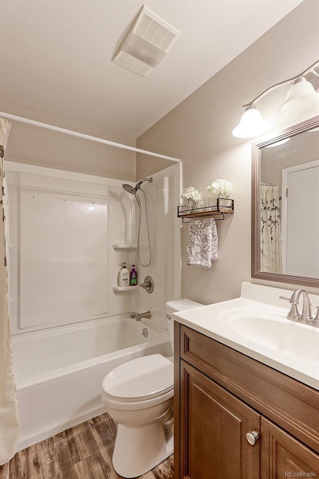 full bath featuring shower / tub combo, visible vents, a textured wall, toilet, and wood finished floors